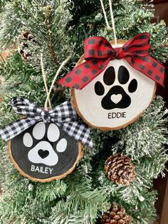 an ornament hanging from a christmas tree with a dog's paw and name on it