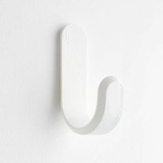 a white wall mounted object with a curved handle on it's left hand side