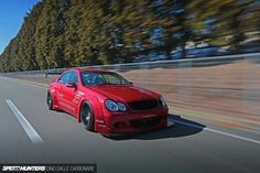 a red sports car driving down the road