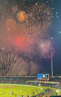 fireworks are lit up in the sky above a baseball field