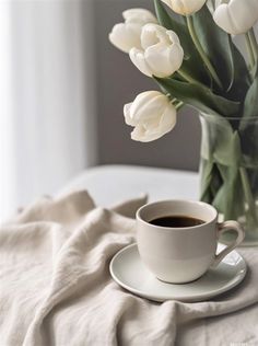 a cup of coffee and some white tulips