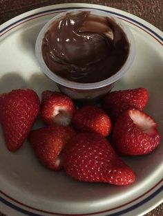 some strawberries and chocolate spread on a plate