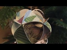 an ornament hanging from a christmas tree decorated with leaves and other things on it