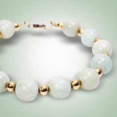 a bracelet with white and gold beads