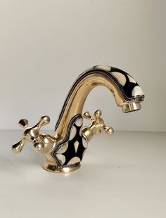 a gold faucet with black and white designs on it's body, in the shape of a giraffe