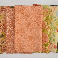 six different colors of fabric with flowers and leaves on them, all lined up in rows