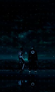 two people standing in the water at night with their backs to each other and stars above them