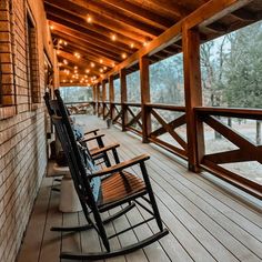 two rocking chairs on a porch with string lights