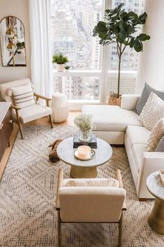 a living room with couches, chairs and a coffee table in front of a large window