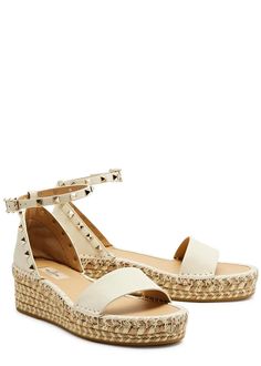 Info & Care:.Valentino Garavani grained leather espadrilles.Espadrille wedge heel measures 2 inches/ 50mm.Rockstud embellishments, whipstitch trims, metallic weave at wedge sole, rubber sole, round toe.Adjustable buckle-fastening ankle strap.Size & Fit:.Displayable Product Name: Rockstud 50 leather wedge espadrilles.Style Number: 956982.Merret Style Number: 956982.Department Description: WOMENS SHOES.Department Number: 140.Visible In Search: true.Season: RA23.Supplier Brand: VALENTINOG.Family Of Business: 006.Runs To Size: This style runs true to size.Restricted Delivery UK: false.Restricted Delivery Europe Exc Ireland: false.Restricted Delivery Ireland: false.Restricted Delivery America: false.Restricted Delivery Asia Exc Hong Kong: false.Restricted Delivery Hong Kong: true.Restricted Del Summer Wedge Sandals With Studded Rubber Outsoles, Summer Wedge Sandals With Studded Outsoles, Flat Heel Espadrilles With Branded Heel Counter For Summer, Valentino Garavani Shoes, Espadrilles Style, Wedges Shoes, Wedge Espadrilles, Leather Espadrilles, Valentino Rockstud