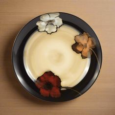 a black plate with flowers painted on it