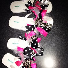 several pairs of flip flops with bows on them sitting on a black table next to each other