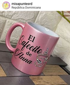 a pink coffee mug sitting on top of a wooden table