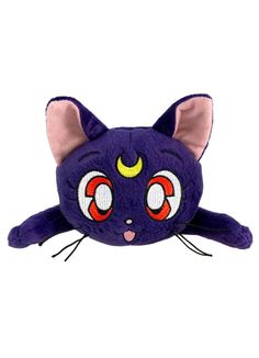 a purple stuffed animal with red eyes and yellow horns on it's head, laying down