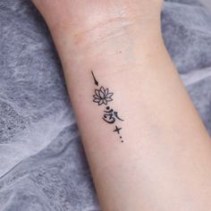 a woman's wrist with a small tattoo design on the left side of her arm