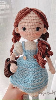 a crocheted doll is wearing a blue dress