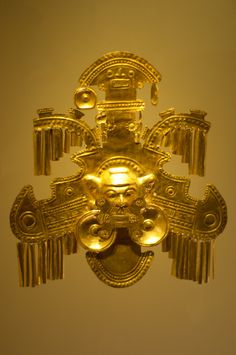 a gold mask hanging from the side of a wall