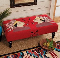 a red bench sitting on top of a rug next to a bowl of olives