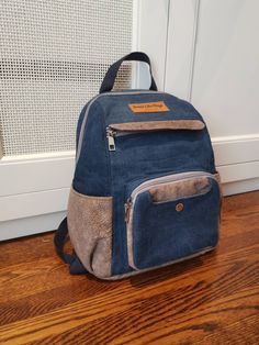 "Cute backpack hand made with upcycled denim and suede-like materials. Perfect for work, school or a day on the town. Features muktiple pockets on the front and back, as well as one inaide. Product Size: Width 13cm (5\"), Length 25cm (10\"), Height 32cm (12 1/2\")." Denim Blue Backpack For Travel, Denim Blue Backpack For Daily Use, Travel Denim Backpack, Denim Travel Backpack, Everyday Denim Standard Backpack, Daily Denim Backpack, Everyday Denim Blue Backpack With Pockets, Denim Blue Backpack With Pockets For Everyday Use, Denim Backpack With Pockets For Everyday Use