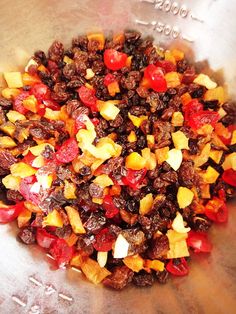 a metal bowl filled with fruit and raisins