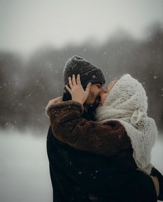 a woman is hugging her head in the snow