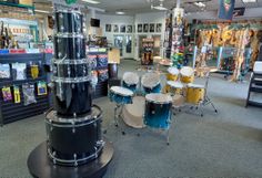 the drums are on display in the store's music section, and there is also an assortment of other musical instruments