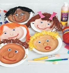 paper plates with children's faces on them next to crayons and markers