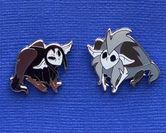 two pins with cartoon characters on them, one is black and the other is white