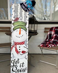 a snowman standing next to a sign that says get it snow