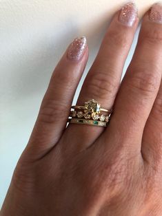 a woman's hand with two rings on it and one ring in the middle