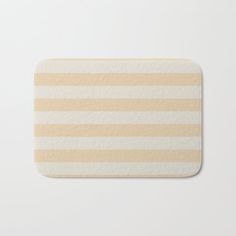 a beige and white striped bath mat on a white surface with no one in it