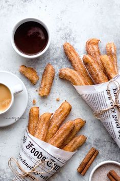 cinnamon sugar churros and two cups of coffee are on the table next to each other