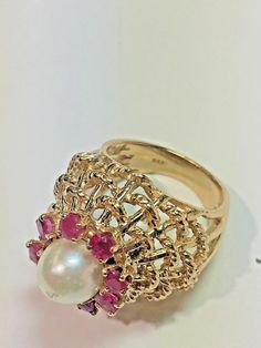 Vintage 14k Yellow Gold Dome White Pearl Red Ruby Domed Basket Weave Ring Size 5 Metal: 14k yellow gold, stamped Stones: (8) Natural Rubies measuring 2.5mm each, (1) Natural White Pearl Measuring 7.5mm with slight wear on top of the pearl Ring Size: 5 (can be resized upon request) Size: Sits 17mm high off the finger, Center cluster measures 15mm in diameter, 20mm wide (north to south) Hallmarked: 14k Textured rope design details on the basket This is an estate piece in very good condition. Pleas Fine Jewelry Yellow Gold Ruby Ring With Intricate Design, 14k Yellow Gold Ruby Ring With Intricate Design, White Ruby Ring In 14k Gold, Yellow Gold Ruby Jewelry Stamped 14k, Gold Ruby Ring Stamped 14k, Gold Ruby Ring With Intricate Design, Fine Jewelry Gold Ruby Ring With Intricate Design, Yellow Gold Ruby Ring With Intricate Design, Exquisite Multi-stone Yellow Gold Ruby Ring