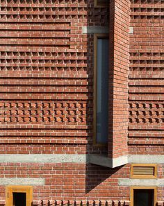 a red brick building with two windows on each side and one window in the middle