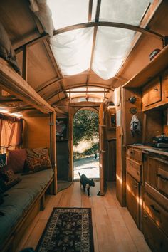 a dog is standing in the doorway of a tiny house with wood floors and walls