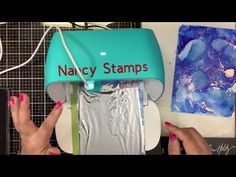 two hands holding onto a blue and silver stamping machine with the word nacy stamps on it