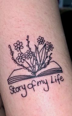 an open book with flowers and the words story & my life written in black ink