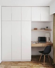 a room with white cabinets and a desk