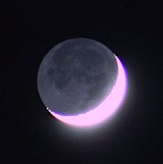 the moon is visible in the dark sky with no light on it's side