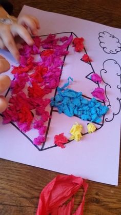 a child is working on crafts with tissue paper