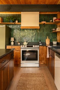 a kitchen with wooden cabinets and green tile backsplashing on the wall above the stove