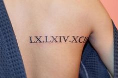 a woman's arm with roman numerals tattooed on her left upper arm