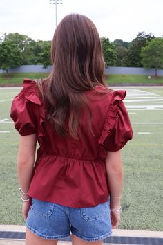 Elevate your wardrobe with our Maroon Peplum Ruffle Top! Made from high-quality poplin cotton, this top features puff sleeves and feminine ruffle details. With ties at each side, it offers a perfect fit. Whether for pre-fall or gameday, it's a must-have addition to your collection! Maroon peplum ruffle top Poplin cotton Puff sleeves Peplum hem Side ties Gameday top Maroon gameday top