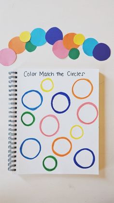 a spiral notebook with colored circles on it and the words color match the circles written in black