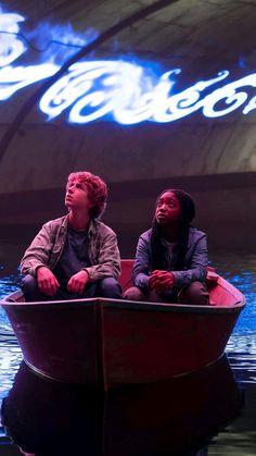 two people are sitting in a boat on the water, one is looking up at the sky