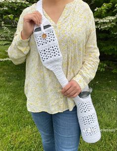 a woman holding a crocheted cell phone case