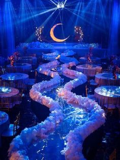 a stage set up for a party with blue lighting and white linens on the floor