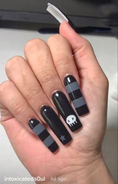 a woman's hand with black and white nail polish