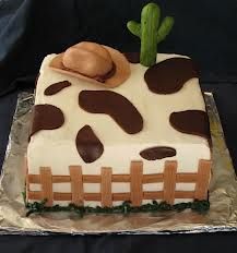 a cake that has been decorated to look like a cow with a hat on top