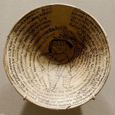 a bowl with writing on it and a drawing in the middle of the bowl is shown